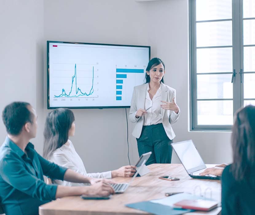 A female doing a presentation in front of her co-workers. 