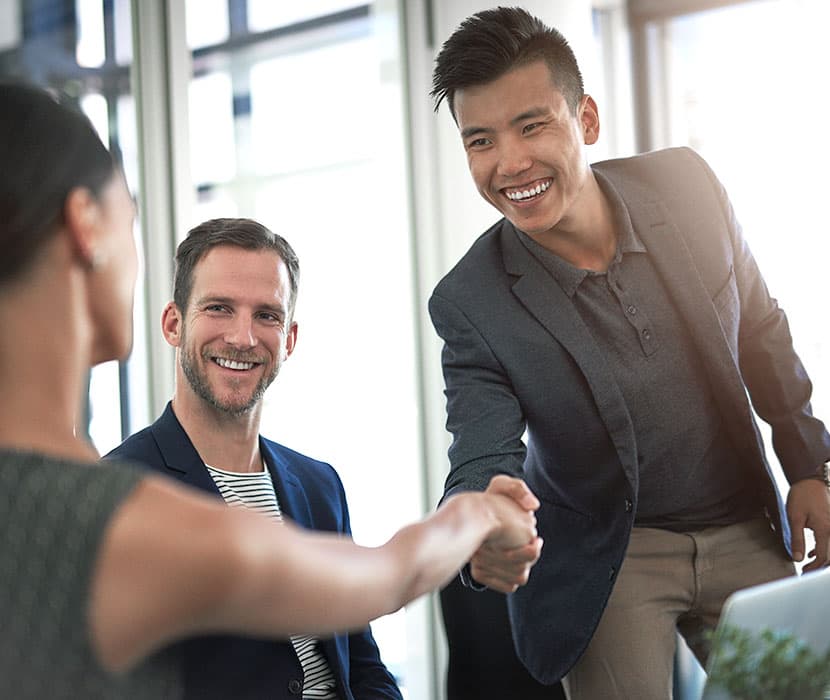 An asian male shaking hands with a female in the office