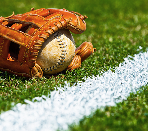 Baseball glove and ball on grass