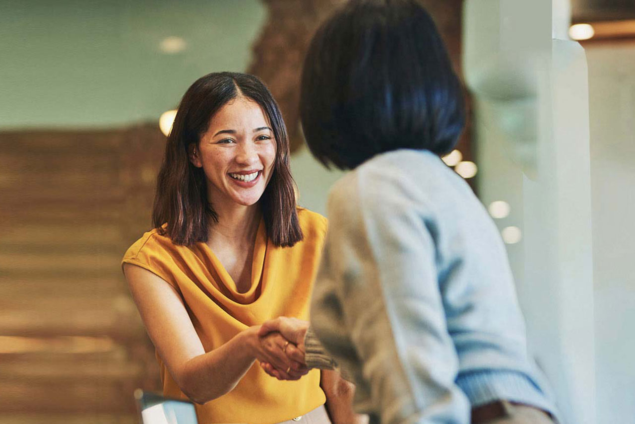 Image of a female coworkers shaking hands.